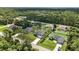 Drone shot of the property, lush landscape, nearby homes, and greenery at 4098 New Milford St, North Port, FL 34288