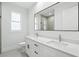 Bright bathroom featuring double vanity with quartz countertop and a large mirror at 4098 New Milford St, North Port, FL 34288