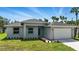 Beautiful single-story home with well-maintained landscaping, light gray siding, and a two car garage at 4098 New Milford St, North Port, FL 34288