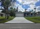 Charming single-story home featuring a gray exterior, attached garage, a well-manicured lawn, and a long driveway at 4098 New Milford St, North Port, FL 34288