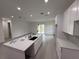 Open kitchen featuring white cabinets, quartz countertops, and stainless steel sink at 4098 New Milford St, North Port, FL 34288