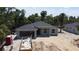 New construction home featuring a spacious garage, a sleek gray roof and walls, and surrounded by lush palm trees at 4098 New Milford St, North Port, FL 34288