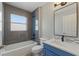 Bathroom featuring a tub, shower, and modern blue vanity with granite countertops at 19713 Ellendale Dr, Land O Lakes, FL 34638