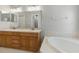 Bathroom with double sink vanity, soaking tub with tile surround, and neutral color palette at 19713 Ellendale Dr, Land O Lakes, FL 34638