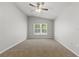 A carpeted bedroom with a ceiling fan, recessed lighting, and a large window with wooded view at 19713 Ellendale Dr, Land O Lakes, FL 34638