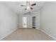 Empty bedroom with neutral carpet, high ceiling, ceiling fan and two entry points for closets or en-suite bathroom at 19713 Ellendale Dr, Land O Lakes, FL 34638