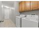 Bright laundry room with side by side washer and dryer and storage cabinets at 19713 Ellendale Dr, Land O Lakes, FL 34638