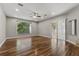 A spacious living room with hardwood floors, a ceiling fan, recessed lights, a sliding glass door, and large window at 19713 Ellendale Dr, Land O Lakes, FL 34638