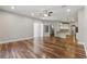 A spacious open-concept living room featuring hardwood floors, ceiling fan, sliding glass door, and an open bar/kitchen area at 19713 Ellendale Dr, Land O Lakes, FL 34638