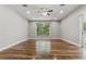 Spacious and bright living room featuring wood floors, large window with view to exterior, fan, and recessed lighting at 19713 Ellendale Dr, Land O Lakes, FL 34638