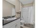 Nicely appointed bathroom with a tub, white vanity with granite countertop, and neutral wall color at 13475 Crest Lake Dr, Hudson, FL 34669
