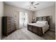 Comfortable bedroom with hardwood floors, large window, ceiling fan, and ample closet space at 13475 Crest Lake Dr, Hudson, FL 34669