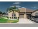Inviting single-story home with a tidy lawn, two-car garage, and curb appeal at 13475 Crest Lake Dr, Hudson, FL 34669