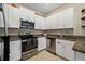 Well-equipped kitchen featuring white cabinets, granite countertops, and stainless steel appliances at 13475 Crest Lake Dr, Hudson, FL 34669