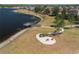 A serene lakefront scene with a charming wooden pier, walking path, and fire pit area for outdoor enjoyment at 13475 Crest Lake Dr, Hudson, FL 34669