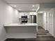 Modern kitchen features white cabinets, stainless steel appliances, quartz counters, and wood-look floors at 1799 N Highland Ave # 143, Clearwater, FL 33755