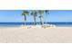 A picturesque beach scene featuring palm trees, turquoise chairs, rocks, and the ocean at 5036 Bonito Dr, New Port Richey, FL 34652