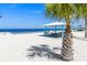 A scenic view of a sandy beach featuring a picnic area, tables, and ocean views at 5036 Bonito Dr, New Port Richey, FL 34652