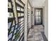 A covered entryway and secure decorative metal security gate lead to the modern front door at 5036 Bonito Dr, New Port Richey, FL 34652