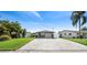 A well-maintained home with green lawn, front palm tree and driveway with gray stone pavers at 5036 Bonito Dr, New Port Richey, FL 34652