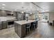 A newly remodeled kitchen with large center island, stainless appliances, pendant lighting and light gray flooring at 5036 Bonito Dr, New Port Richey, FL 34652