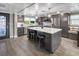 Modern kitchen with gray cabinets, island with seating, stainless steel appliances, and wood-look flooring at 5036 Bonito Dr, New Port Richey, FL 34652