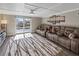 Comfortable living room with a large reclining sofa, stylish rug, and sliding glass doors to the pool area at 5036 Bonito Dr, New Port Richey, FL 34652