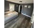 Cozy bedroom with gray walls, wood-look floors, and a comfortable daybed, offering a relaxing and stylish retreat at 8702 El Portal Dr, Tampa, FL 33604
