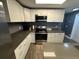 Bright kitchen featuring stainless steel appliances, white cabinetry, and gray countertops, offering a clean and modern aesthetic at 8702 El Portal Dr, Tampa, FL 33604