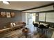 Inviting living room with modern furnishings, wood-look floors, and natural light, seamlessly connected to the dining area at 8702 El Portal Dr, Tampa, FL 33604