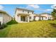 Backyard with lush green lawn, covered patio, and attractive rear elevation of the home at 6018 Jensen View Ave, Apollo Beach, FL 33572
