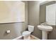 A half bathroom with neutral walls, wood-look floors, and white fixtures at 6018 Jensen View Ave, Apollo Beach, FL 33572