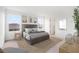 Stylishly staged bedroom with beach art prints, soft gray bedding, and natural light at 6018 Jensen View Ave, Apollo Beach, FL 33572