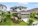 Two-story home featuring an attached garage, stone accents, and landscaping at 6018 Jensen View Ave, Apollo Beach, FL 33572