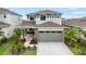 Two-story home featuring an attached garage, stone accents, and landscaping at 6018 Jensen View Ave, Apollo Beach, FL 33572