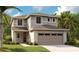 Charming two-story home with neutral siding, stone accents, a two-car garage, and a well-manicured lawn at 6018 Jensen View Ave, Apollo Beach, FL 33572