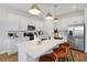Modern kitchen with white cabinets, an island with seating, stainless steel appliances and contemporary pendant lighting at 6018 Jensen View Ave, Apollo Beach, FL 33572