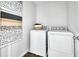 A modern laundry room featuring a washer, dryer, and decorative prints at 6018 Jensen View Ave, Apollo Beach, FL 33572