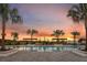 Stunning pool at sunset, featuring palm trees and pergolas, creating a relaxing tropical oasis at 6018 Jensen View Ave, Apollo Beach, FL 33572