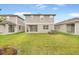 Grassy backyard featuring a covered patio, well-maintained lawn, and gray siding at 6026 Jensen View Ave, Apollo Beach, FL 33572