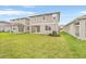 Backyard featuring healthy grass, patio, and the exterior of a gray two story house at 6026 Jensen View Ave, Apollo Beach, FL 33572