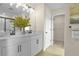 Bathroom featuring double vanity with modern fixtures, white cabinets, and an adjacent walk-in closet at 6026 Jensen View Ave, Apollo Beach, FL 33572