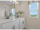 Bright bathroom featuring a double vanity, modern fixtures, and a large window with a scenic view at 6026 Jensen View Ave, Apollo Beach, FL 33572