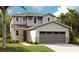 Two-story home featuring neutral colors, attached two-car garage, and nicely landscaped front yard at 6026 Jensen View Ave, Apollo Beach, FL 33572