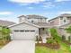 Charming two-story home with a two-car garage, lush landscaping, and a welcoming front porch at 6026 Jensen View Ave, Apollo Beach, FL 33572