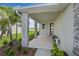 Inviting front porch featuring stone pillars, lush landscaping, and a seating area with a view at 6026 Jensen View Ave, Apollo Beach, FL 33572