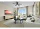 Cozy living room featuring plush seating, a modern entertainment center, and a scenic outdoor view at 6026 Jensen View Ave, Apollo Beach, FL 33572