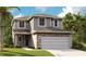Charming two-story home featuring a two-car garage, stone accents, neutral siding, and well-manicured landscaping at 6034 Jensen View Ave, Apollo Beach, FL 33572