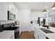 Modern kitchen featuring white cabinets, quartz countertops, stainless appliances, and wood-look tile flooring at 6034 Jensen View Ave, Apollo Beach, FL 33572