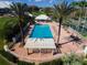 Aerial view of community pool, tennis courts, and clubhouse surrounded by palm trees at 9136 Players Dr, Weeki Wachee, FL 34613